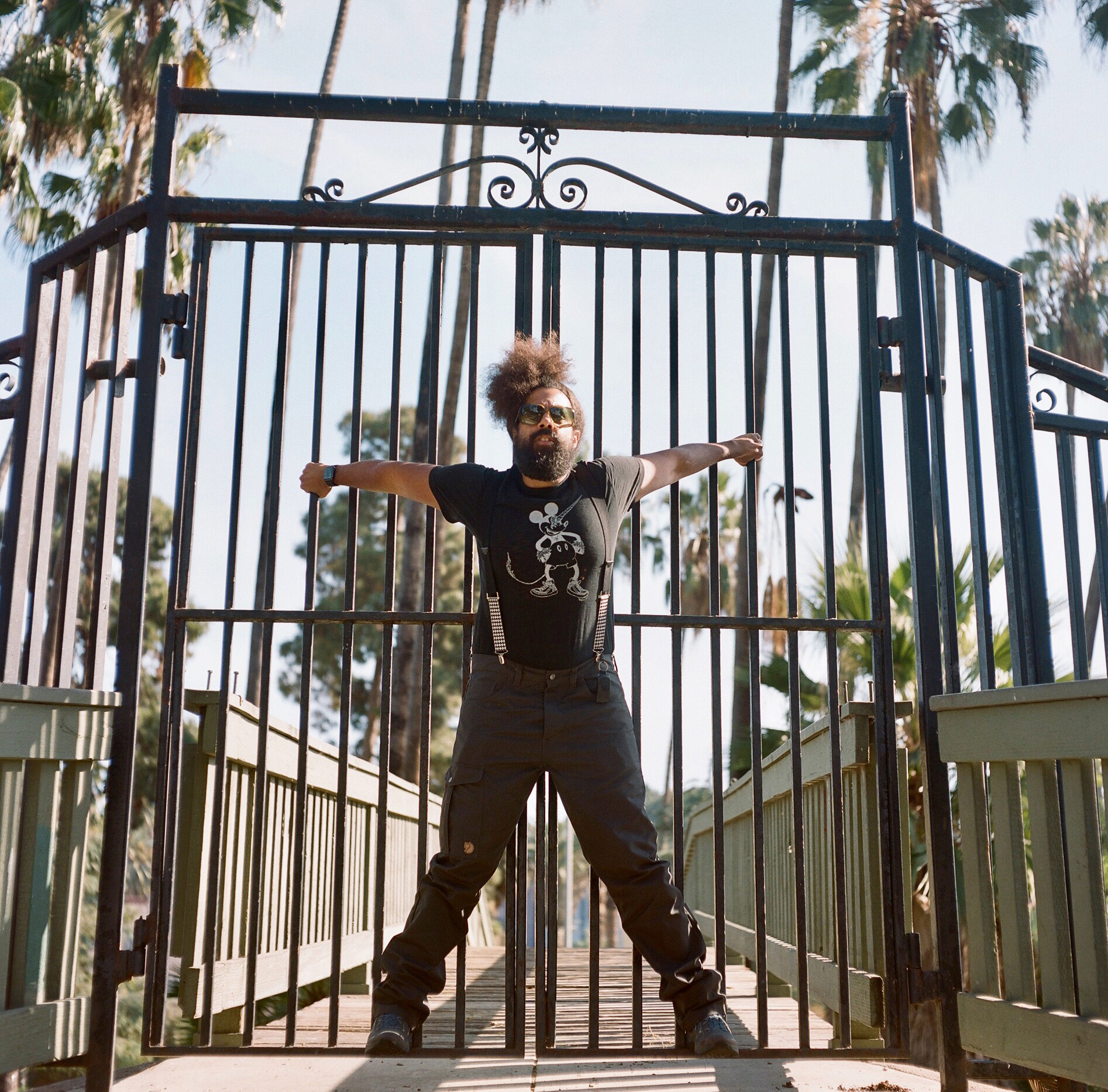 Reggie Watts hanging from a fence